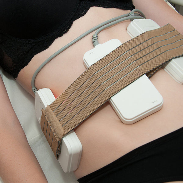 Medical device on a person's abdomen with a brown strap