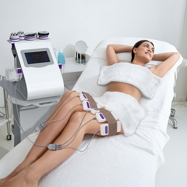 A woman receiving a leg slimming treatment with laser lipo pads in a clinical setting.