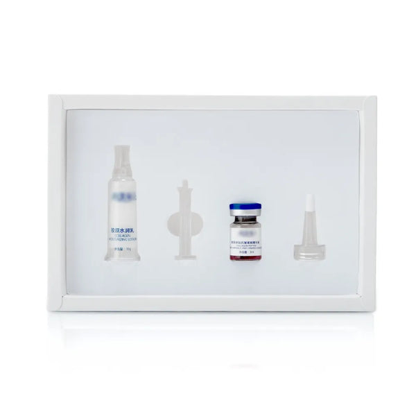 A white rectangular kit box containing four medical or laboratory items: a clear spray bottle with blue text, a small clear vial with a blue cap and red liquid, a clear pipette, and a clear needle tip, all on a white background.