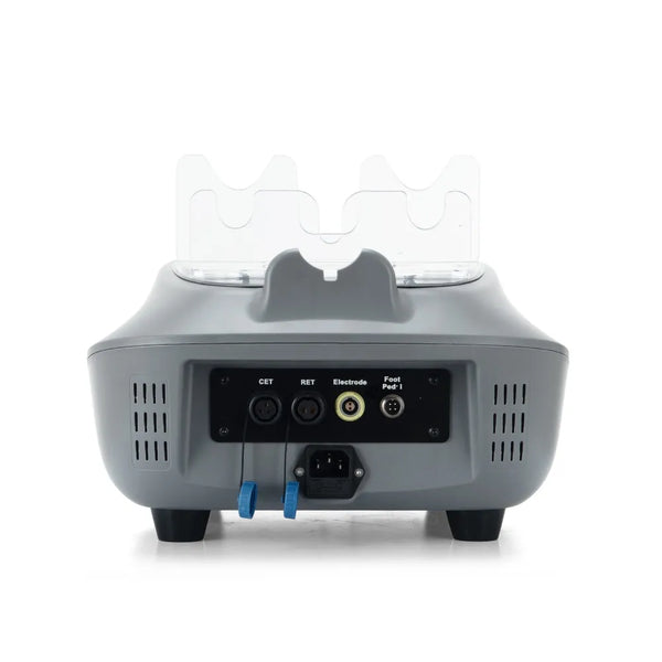 The rear view of a cet ret therapy beauty device, likely an IPL skin treatment unit, featuring a black control panel with input/output ports, power cord, and two blue grounding leads, with two clear protective covers on top.