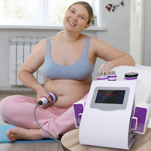 Woman using a home 40k cavitation machine on her abdomen in a bright room.