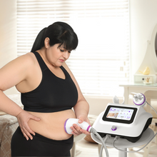 Woman using a home fitness device on her abdomen in a bedroom setting