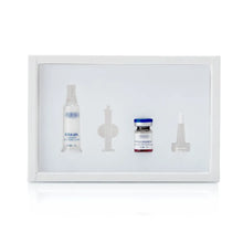 A white rectangular kit box containing four medical or laboratory items: a clear spray bottle with blue text, a small clear vial with a blue cap and red liquid, a clear pipette, and a clear needle tip, all on a white background.