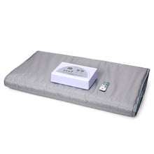 Gray heating pad with a control unit and remote on a white background