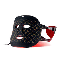 A black LED light therapy face mask with a gold geometric pattern, featuring a red interior lining and adjustable strap, shown on a white background.