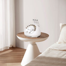 White vintage-style phone on a wooden side table in a bedroom setting